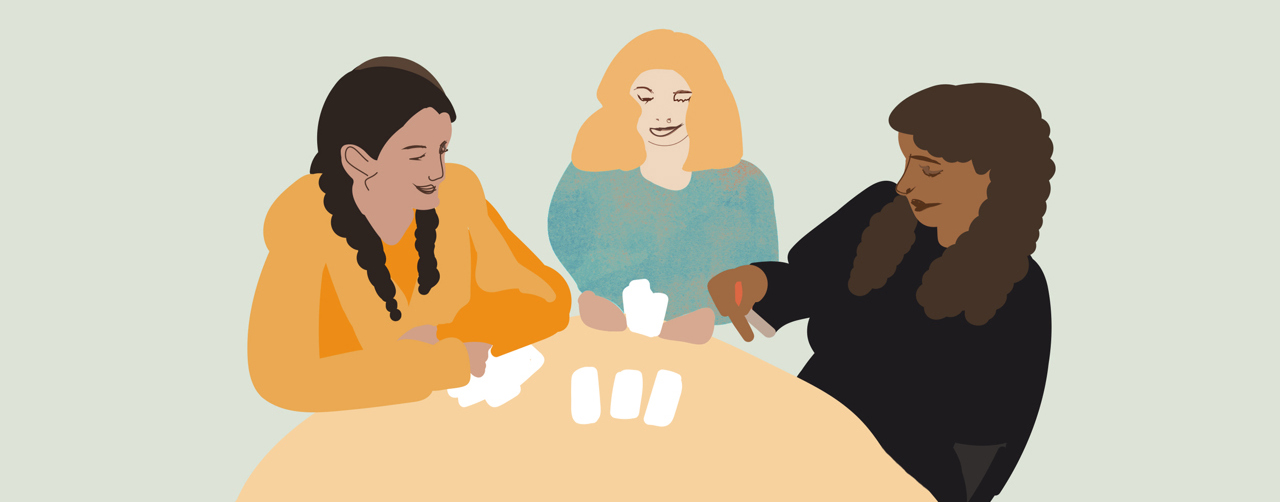 Illustration där tre flickor sitter vid ett bord och spelar kort. 
